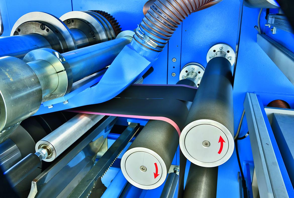Rollenschneider (30 m/min.) mit  austauschbaren Schneideeinheiten mit je 4 Messern und Bürstensystem zur Reinigung der geschnittenen Elektrodenbänder.