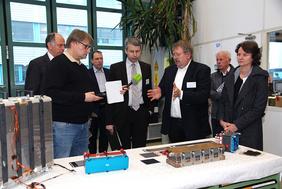 Dr. Ludwig Jörissen, komm. Leiter des Geschäftsbereichs Elektrochemische Energietechnologien am ZSW (3. von re.), erläutert Verkehrsstaatssekretär Steffen Bilger (Mitte) die Brennstoffzellenforschung am ZSW