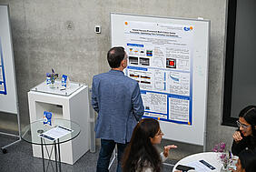 Ein Mann liest sich ein wissenschaftliches Poster durch